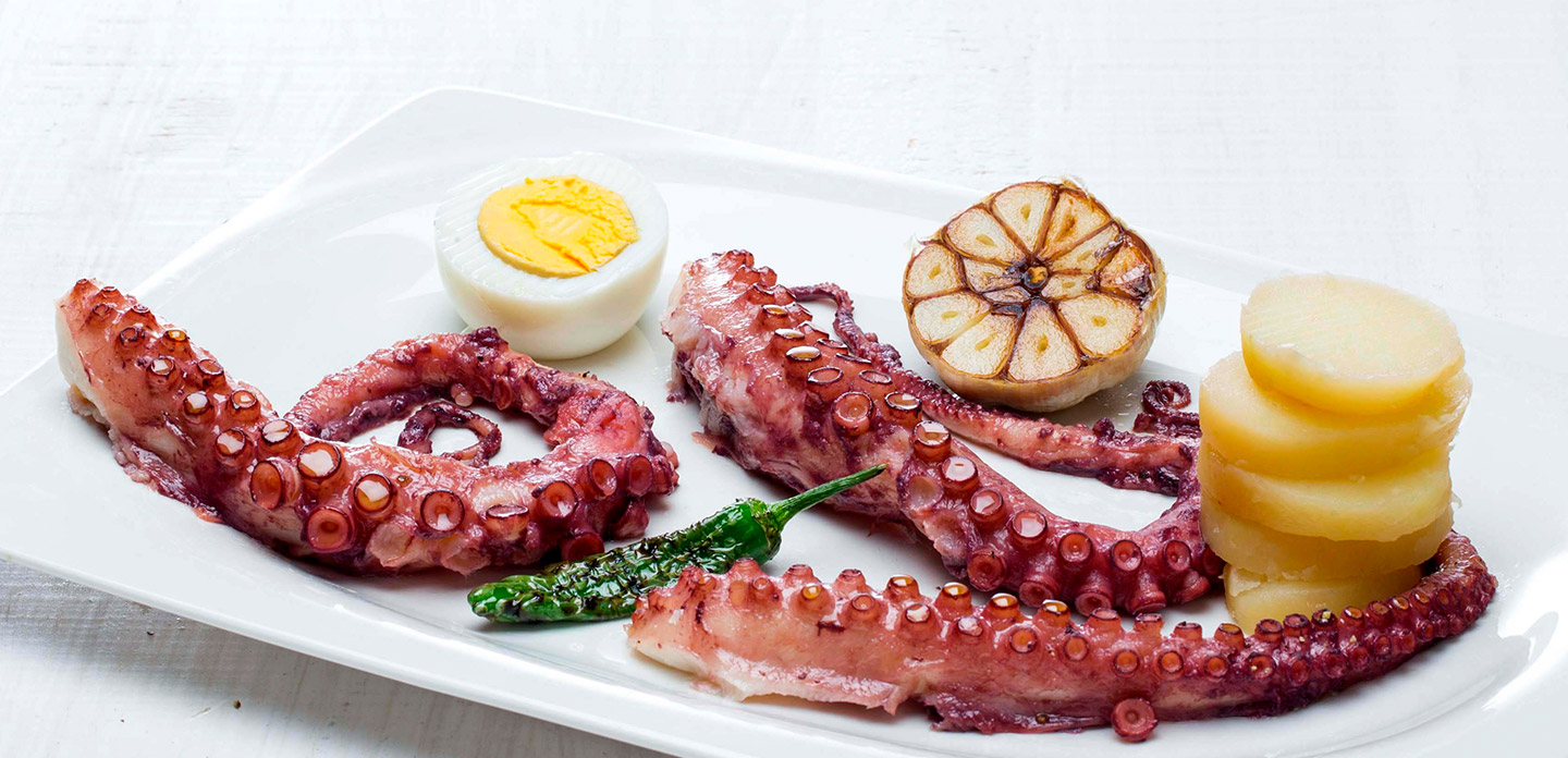 Poulpe cuit à la vapeur, servi avec huile d’ail et piment Padrón avec vinaigre balsamique blanc